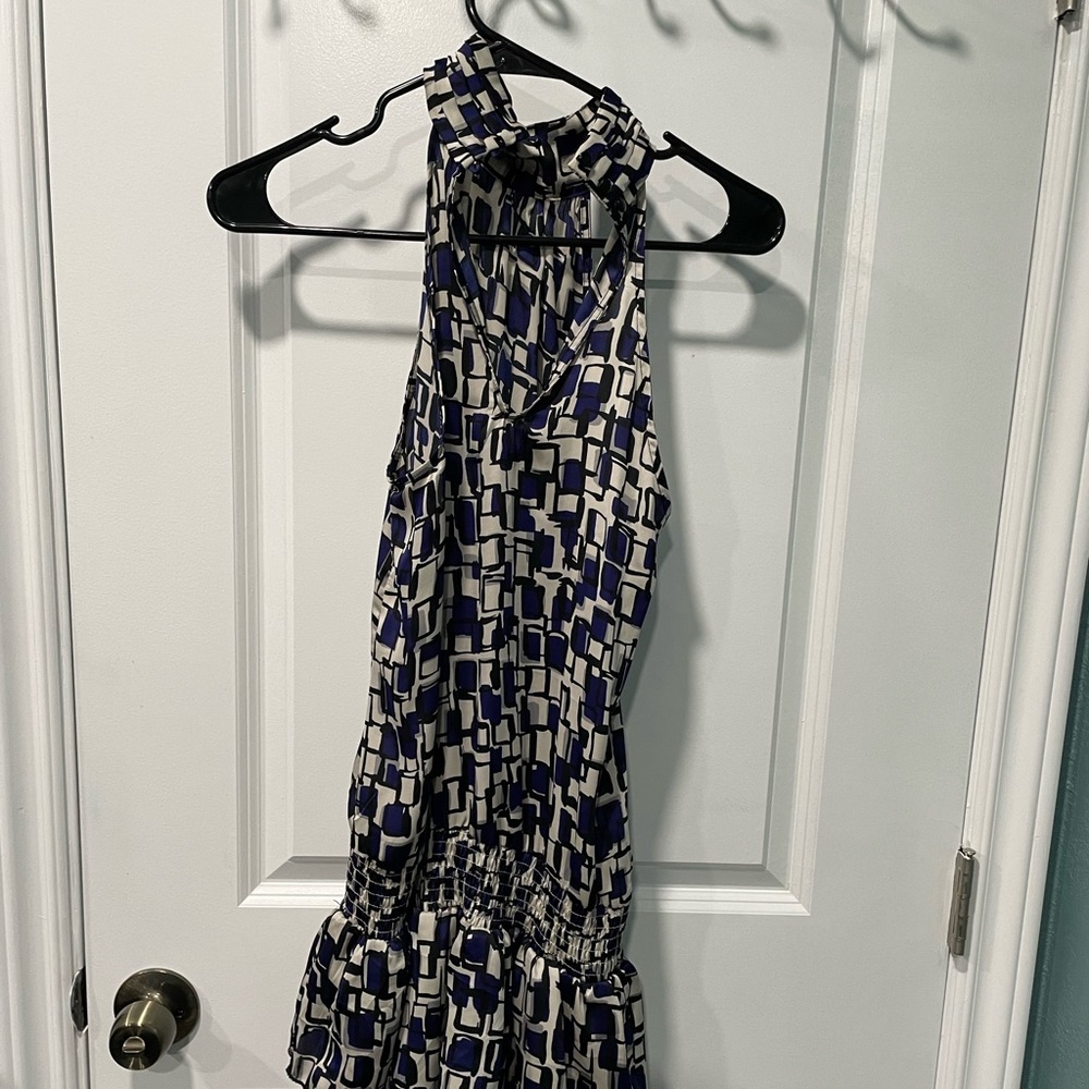 Sleeveless dress, with ruffles at bottom . Buttons at neck